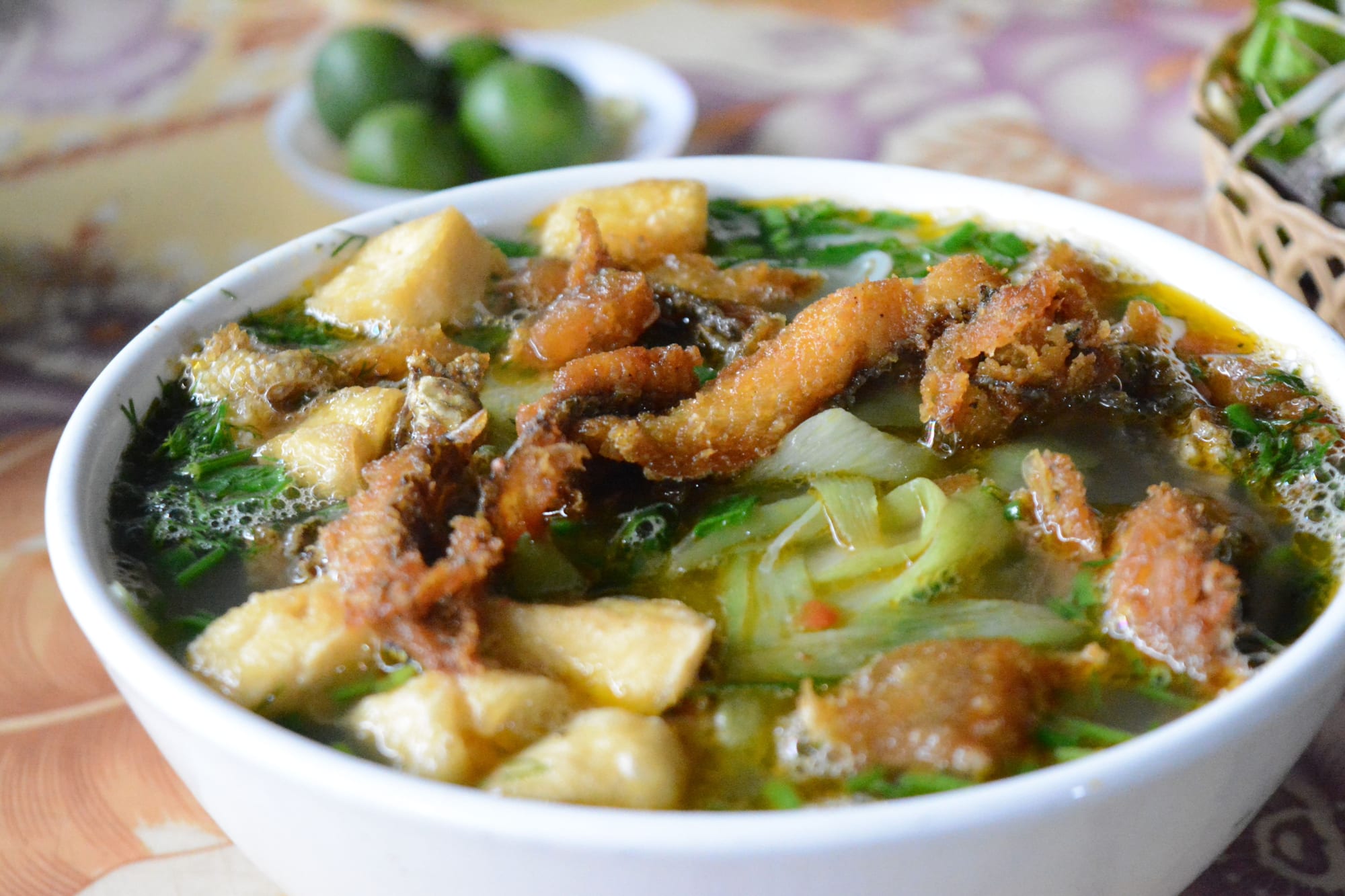 A steaming bowl of Vietnamese fish-cake noodle soup with fresh herbs, the kind of bánh canh chả cá served across Phú Quốc