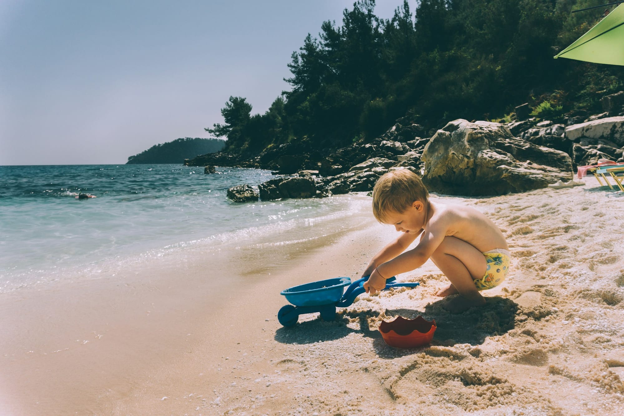 A young child playing at the edge of a calm shallow beach, the kind of gentle entry point families look for at Bãi Trường, Phú Quốc