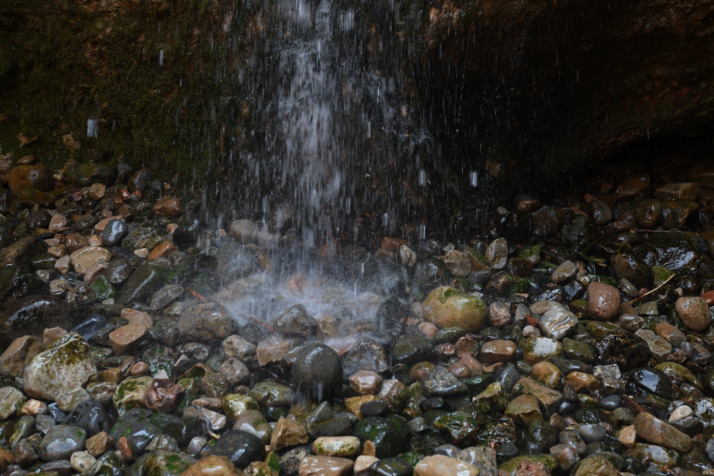 A small waterfall spilling into a rock pool, the kind you find along the Suối Tranh trail