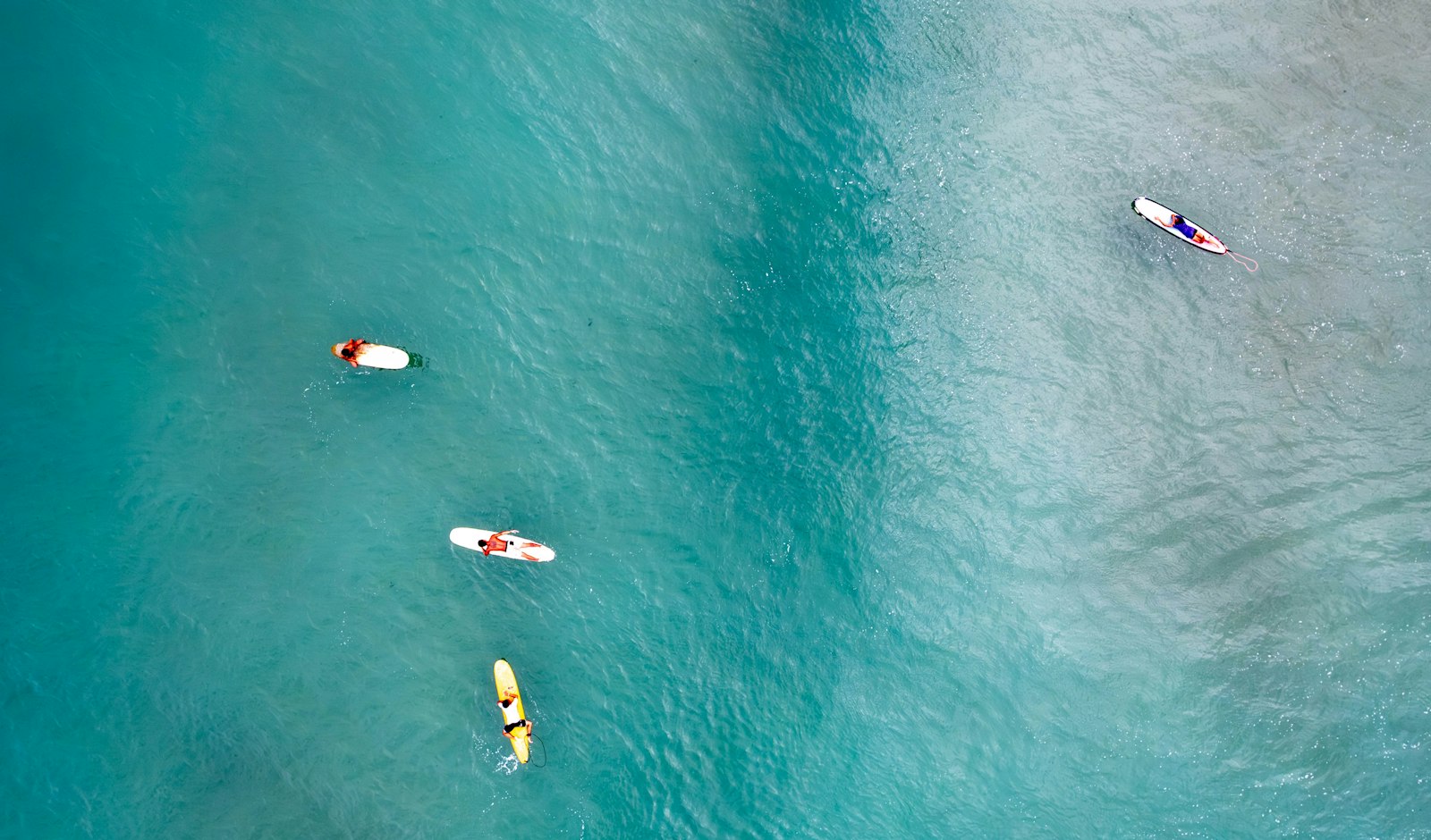 Paddleboarders standing on boards in shallow, clear water, the kind of calm session Bãi Trường offers on a still morning