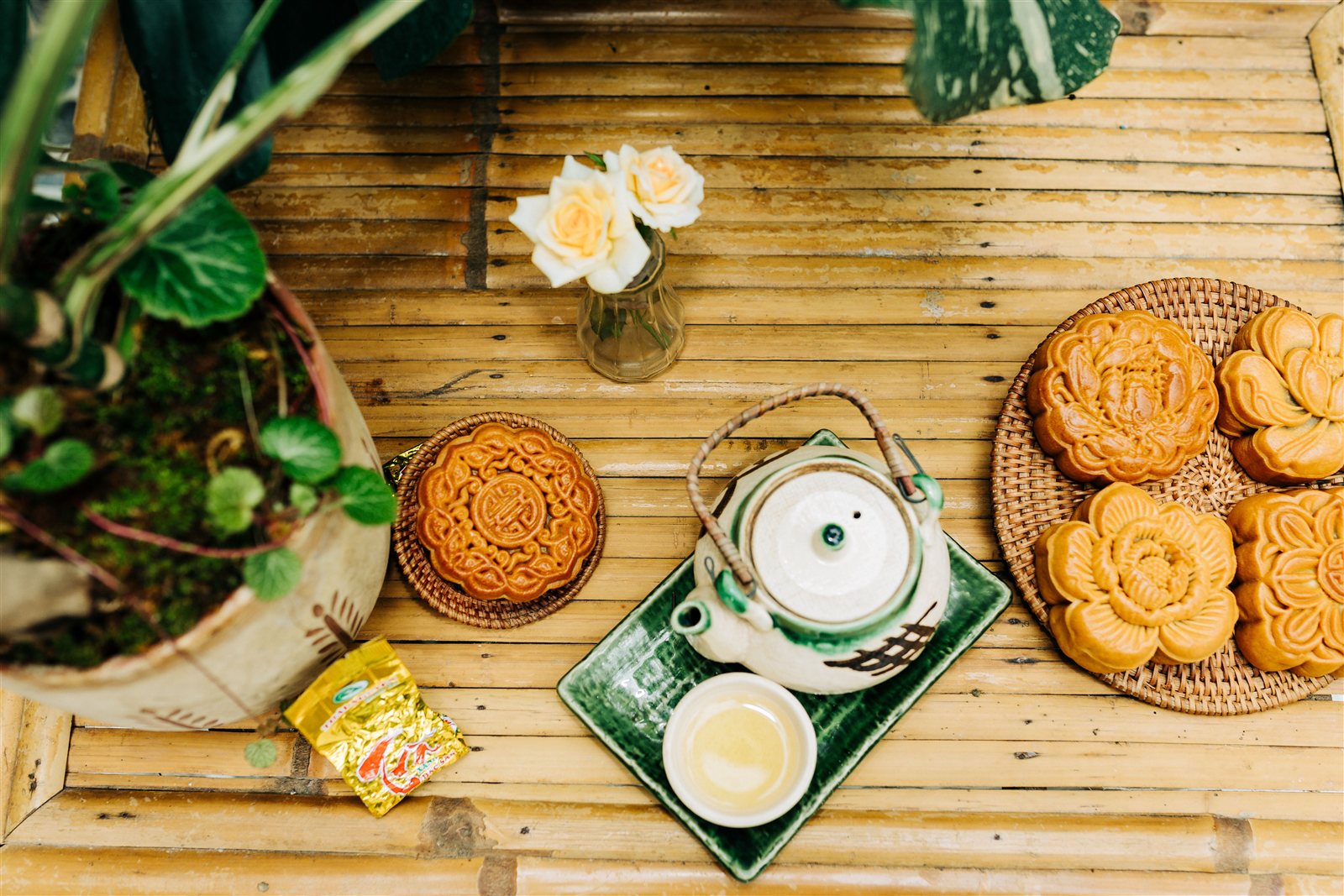 Vietnamese mooncakes and tea arranged on a bamboo table for Mid-Autumn Festival